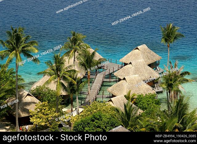 View over thatched overwater bungalows of hotel in lagoon