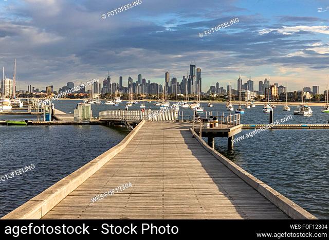 Australia, Victoria, Melbourne, Clouds over Saint Kilda Pier at dusk with city skyline in background
