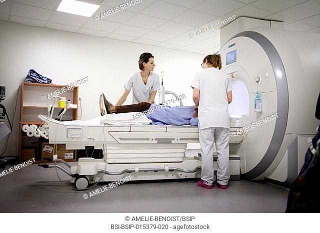 Reportage in a medical imaging service in a hospital in Savoie, France. Two technicians set up a patient for an MRI scan