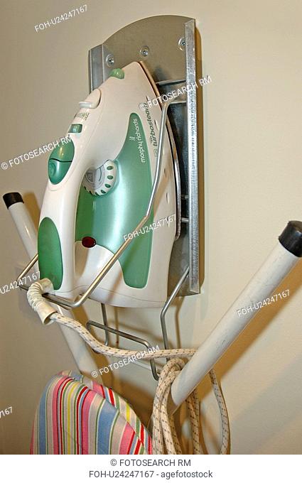 Close up of iron and ironing board stored on wall rack