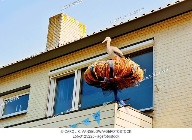 Stork in nest in front of house. A way to announce that you have a new child