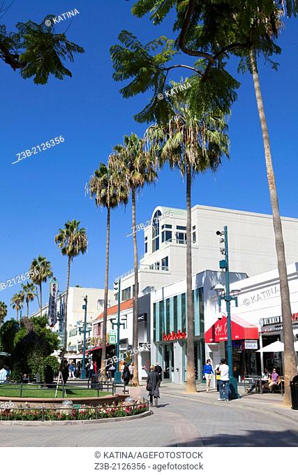 Pedestrians enjoy a sunny afternoon under the palm trees on Third Street Promenade, Santa Monica, City of Los Angeles, California, USA