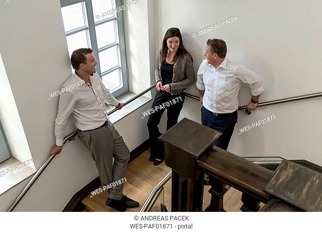 Colleagues standing in staircase talking