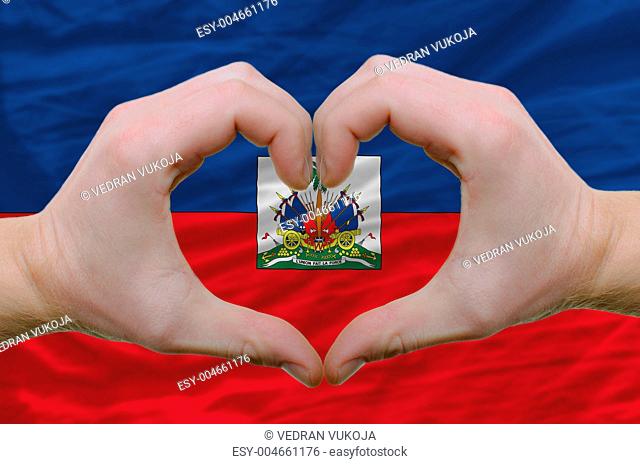 Heart and love gesture showed by hands over flag of haiti backgr
