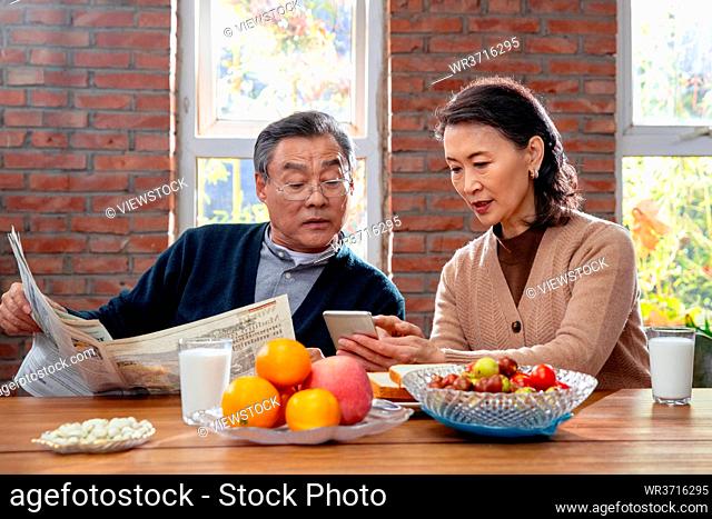 Elderly couple enjoy breakfast at home