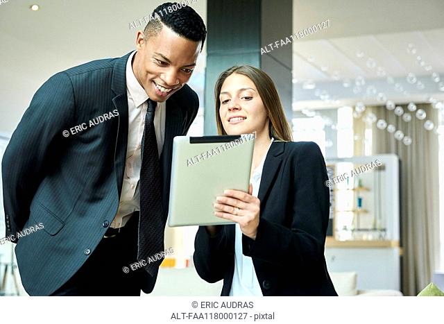 Business people using a digital tablet in hotel lobby