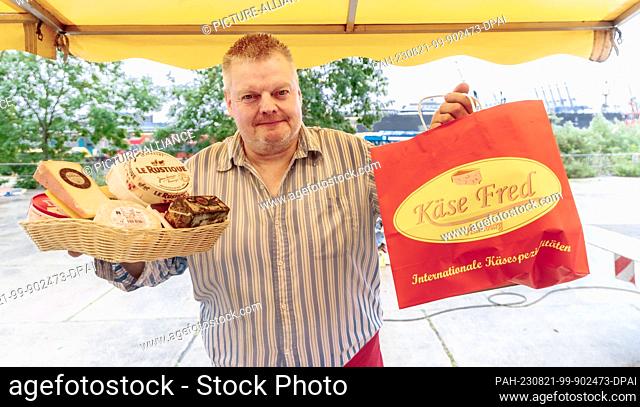 PRODUCTION - 23 July 2023, Hamburg: Axel Pabst sells cheese at the Hamburg fish market. For more than 25 years, Axel Pabst has been working as a market crier...