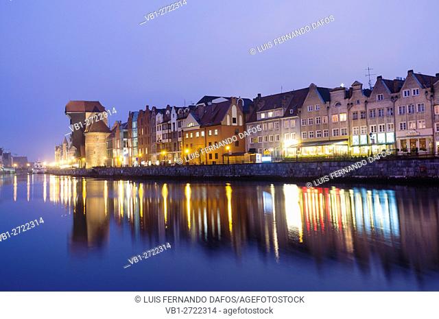 Waterfront tenements and crane reflected on Motlawa river at dusk. Gdansk, Poland