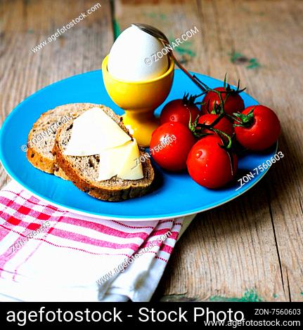 Healthy breakast with eggs and ripe cherry tomatoes on the bright napkin