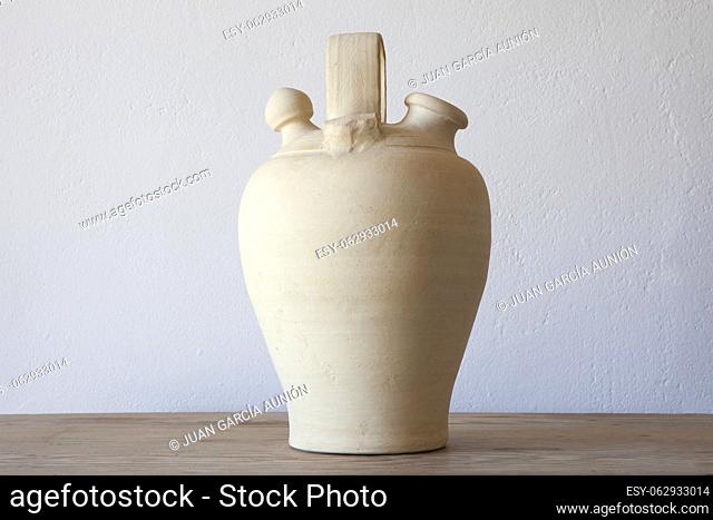 White earthenware botijo, traditional clay pot jug to keep fresh water. Selective focus