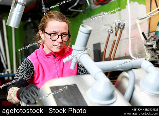 Female plumber working in workshop