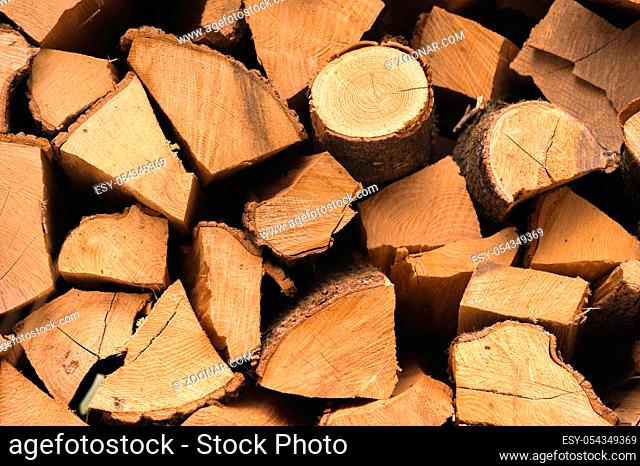 The chopped firewood lies in a flat pile. Close-up
