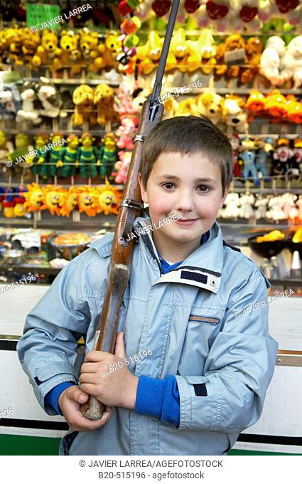 Nine years old boy with rifle in a fair