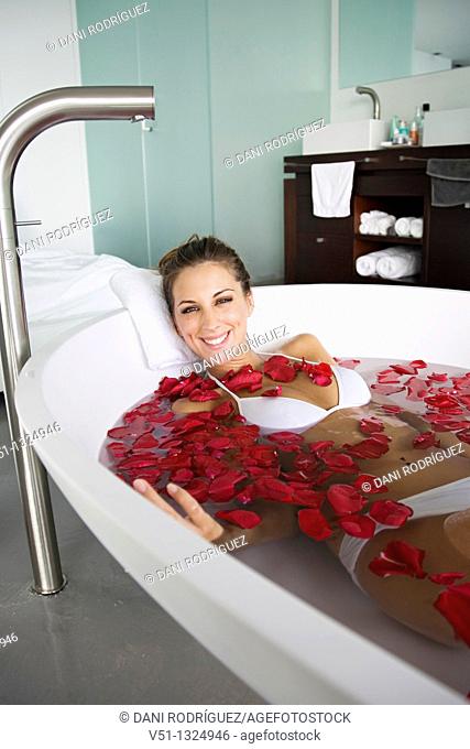 Woman enjoying a bath with roses petals