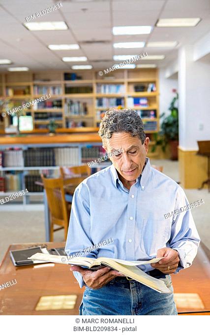 Senior man reading in library