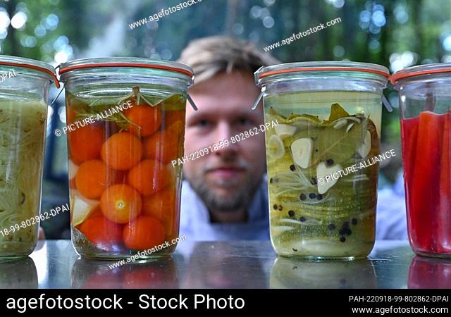 02 September 2022, Brandenburg, Finowfurt: Ricco Stiehn, is one of three members of the Eberswalde cooking commode, shows vegetables fermented in jars