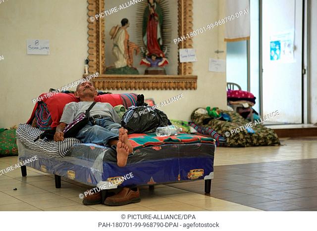 29 June 2018, Guatemala, Escuintla: An elderly man has packed everything that he still has and is lying on a bed in the emergency shelter at the church 'Nuestra...