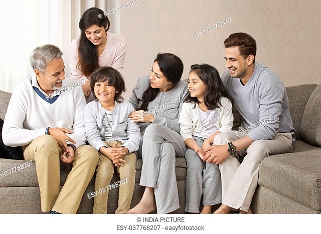 Happy multi-generation family sitting together on sofa