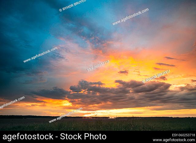 Spring Summer Meadow At Evening Sunset Sunrise. Natural Bright Dramatic Sky In Different Colours Above Countryside Meadow Landscape