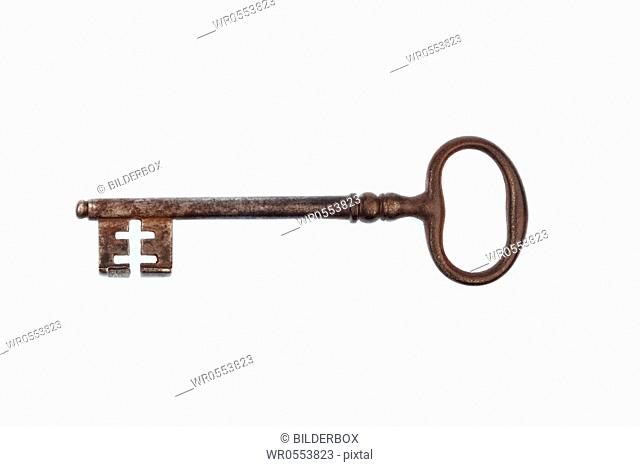 An old key lying on a white background