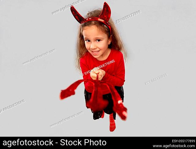 girl with trident and devil's horns on halloween