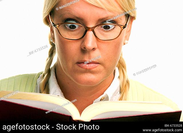 Stunned female with ponytails and book isolated on a white background
