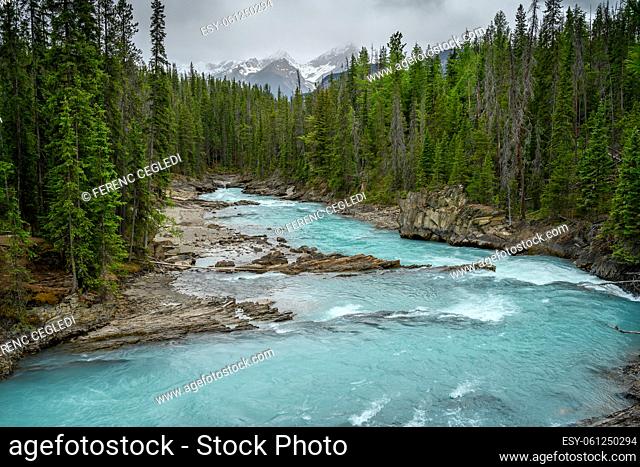 The Kicking Horse River flows down from the mountains, became a waterfall before it goes beneath a natural bridge, Yoho National Park, British Columbia, Canada