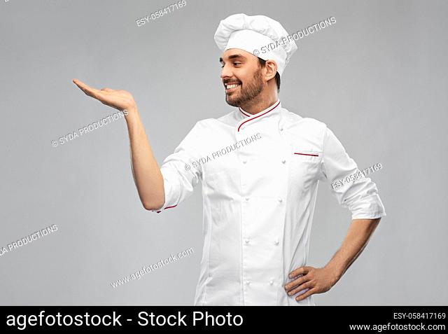 happy smiling male chef holding something on hand
