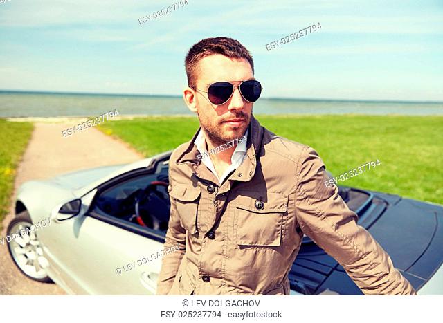 road trip, travel, transport, leisure and people concept - man near cabriolet car outdoors