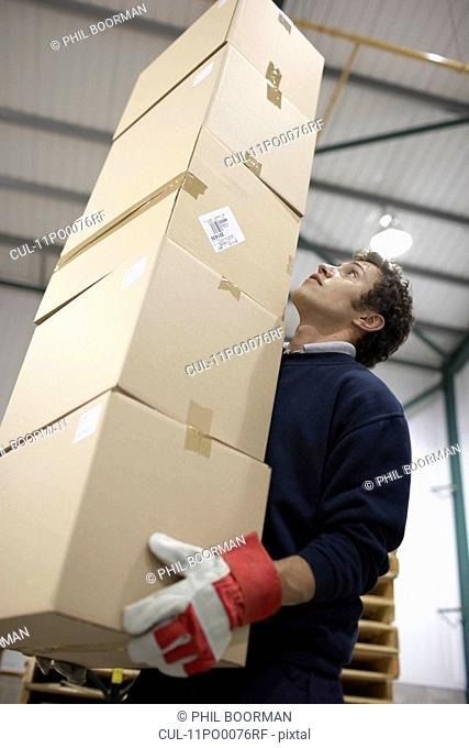 Worker carrying pile of boxes