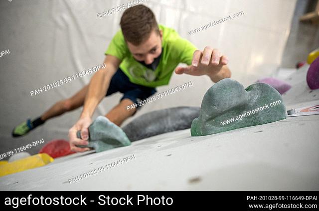 28 October 2020, Baden-Wuerttemberg, Ludwigsburg: A man is bouldering in the climbing and bouldering hall Griffwerk with mouth and nose protection
