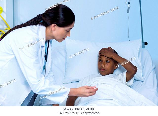 Female doctor checking fever from digital thermometer