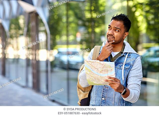 indian man traveling with backpack and map in city