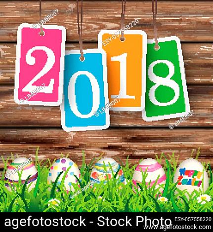 Price stickers with date 2018 on the wooden background with easter eggs in the grass