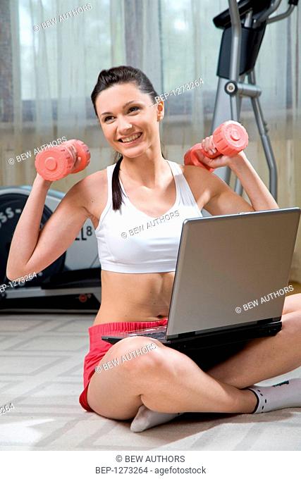Woman doing exercises and working on a laptop