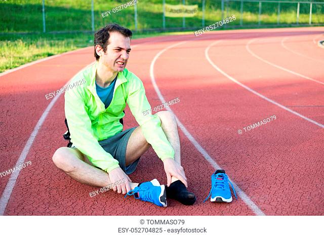 Running athlete feeling pain after an ankle injury