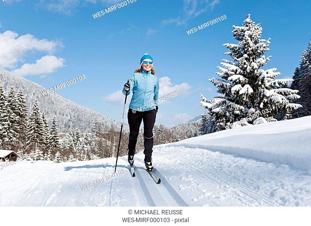 Germany, Bavaria, Aschermoos, Senior woman doing cross-country skiing