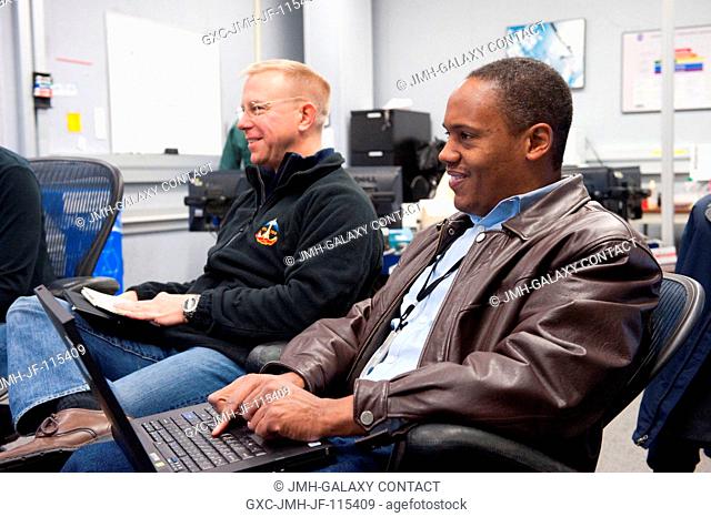 NASA astronauts Tim Kopra (background) and Alvin Drew, both STS-133 mission specialists, participate in a training session in the fixed-base shuttle mission...