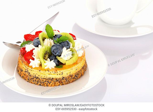 Cheese-cake with strawberry, blueberry, kiwi and cream on white plate