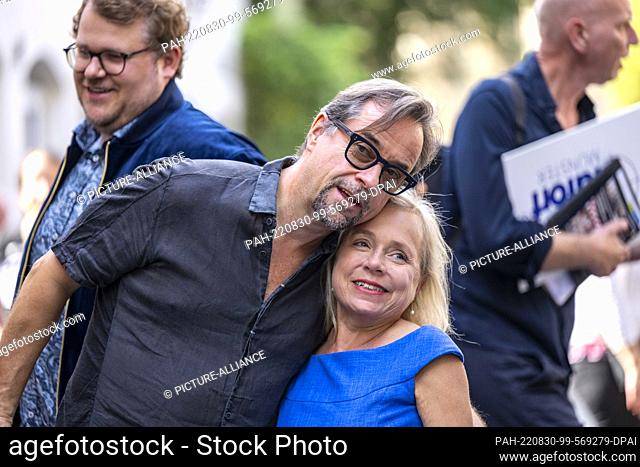30 August 2022, North Rhine-Westphalia, Münster: ""Tatort"" actors Jan Josef Liefers (l) and Christine Urspruch embrace each other