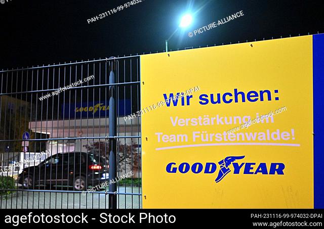 16 November 2023, Brandenburg, Fürstenwalde: In the evening, an advertisement for the reinforcement of the Goodyear team hangs on the fence of the factory...