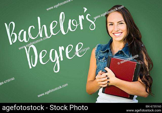 Bachelors degree written on chalk board behind mixed-race young girl student holding books