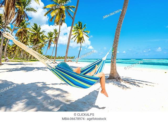 Canto de la Playa, Saona Island, East National Park (Parque Nacional del Este), Dominican Republic, Caribbean Sea. Woman relaxing on a hammock on the beach (MR)