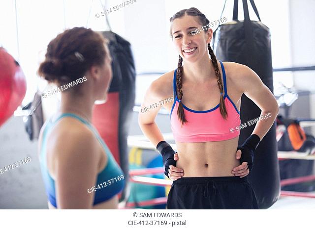 Smiling young female boxers resting in gym