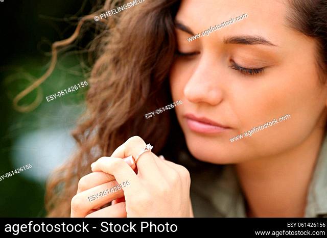 Woman looking at engagement ring in a park