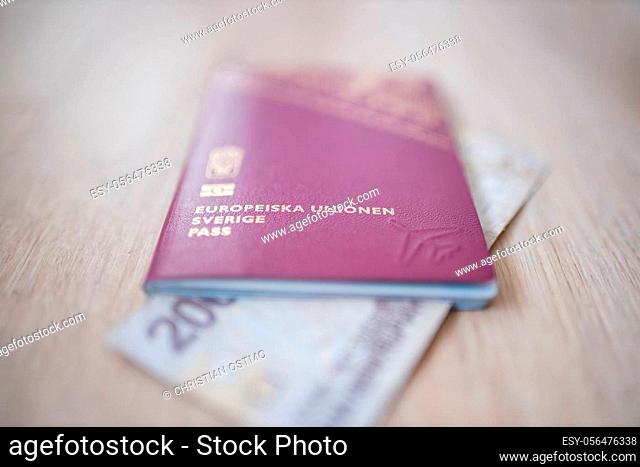 Picture of a Swedish Passport -with the words European Union Sweden Passport in swedish- with a blurry Two Thousand Rupees Bill Partially Inside