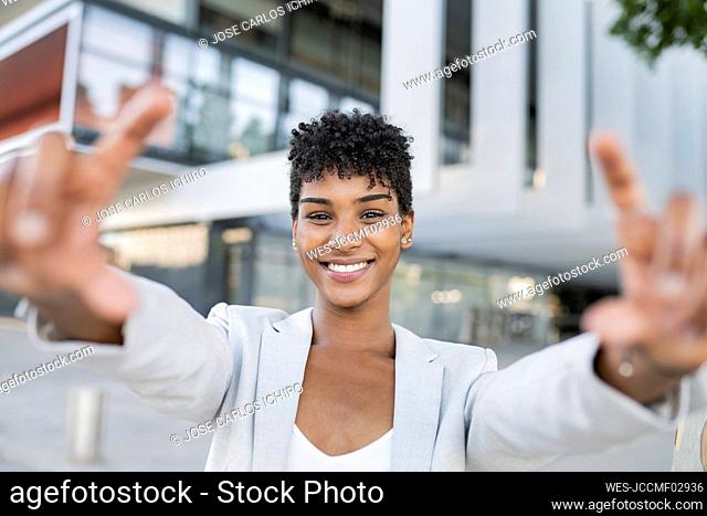 Smiling female professional making finger frame