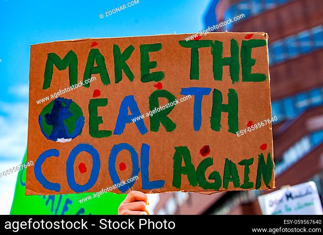 A close up view of a cardboard sign, saying make the earth cool again, as ecological activists stage a street demonstration in Montreal, Canada