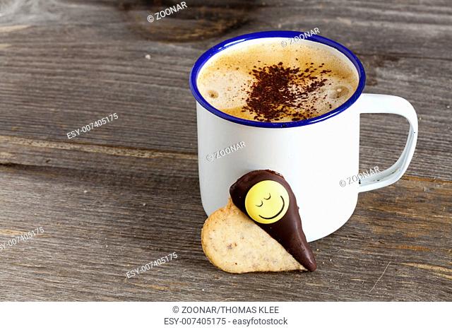 Cup with coffee and cookies with smiley face