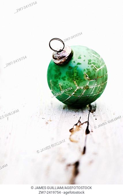 Antique glass Christmas tree trim resting on weathered wooden surface